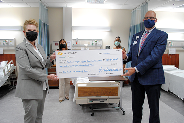 Sentara Halifax Regional President Brian Zwoyer presents a check for $180,000 to SVHEC Executive Director Dr. Betty Adams