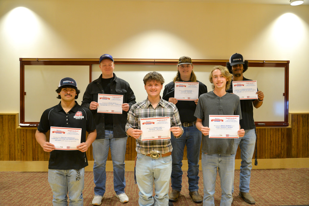 Six youth apprentices holding a certificate.